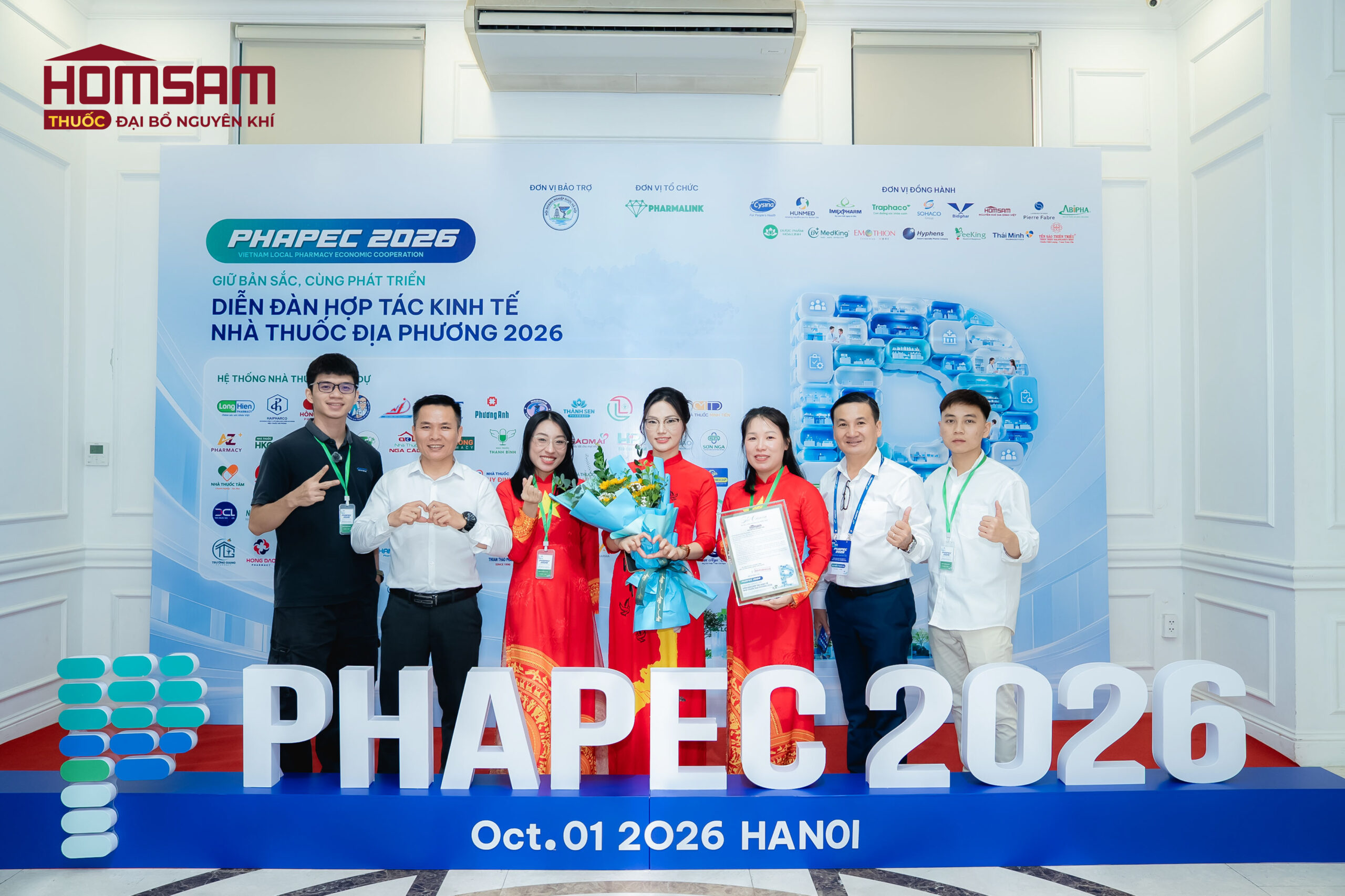 Đại diện thương hiệu HOMSAM nhận lẵng hoa cùng bằng chứng nhận tri ân từ đại diện Ban Tổ chức PHAPEC 2026